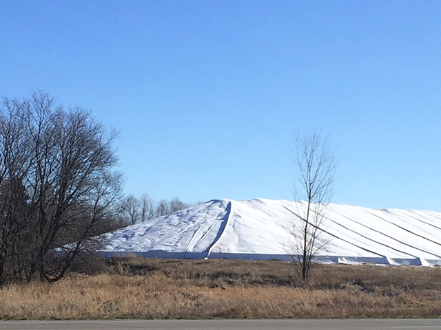 A ground pile of corn near Sartell, Minnesota, on March 27, 2016. This pile stretches out beyond the picture and is approximately 750,000 bushels. Like most piles around the Midwest that are still standing, it has been in the same spot since Harvest 2015. (DTN photo by Mary Kennedy)